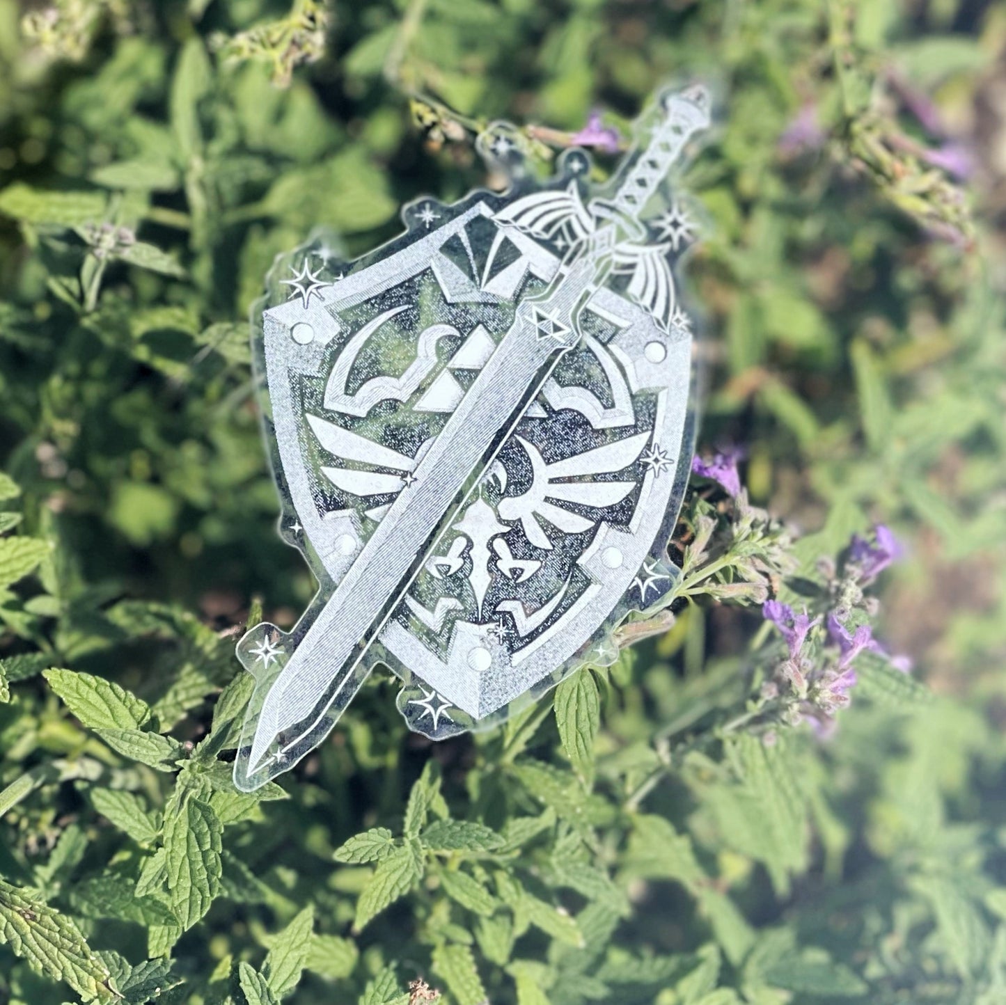 an image of a white ink clear sticker in the style of the master sword and hylian shield from legend of zelda