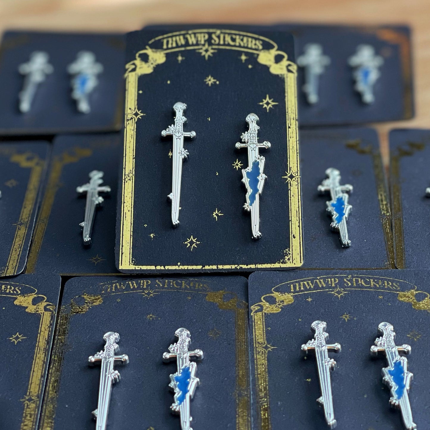 an image depicting the swords of Legend inspired by Narsil and Anduril of lord of the rings fame in enamel pin form with depth of field