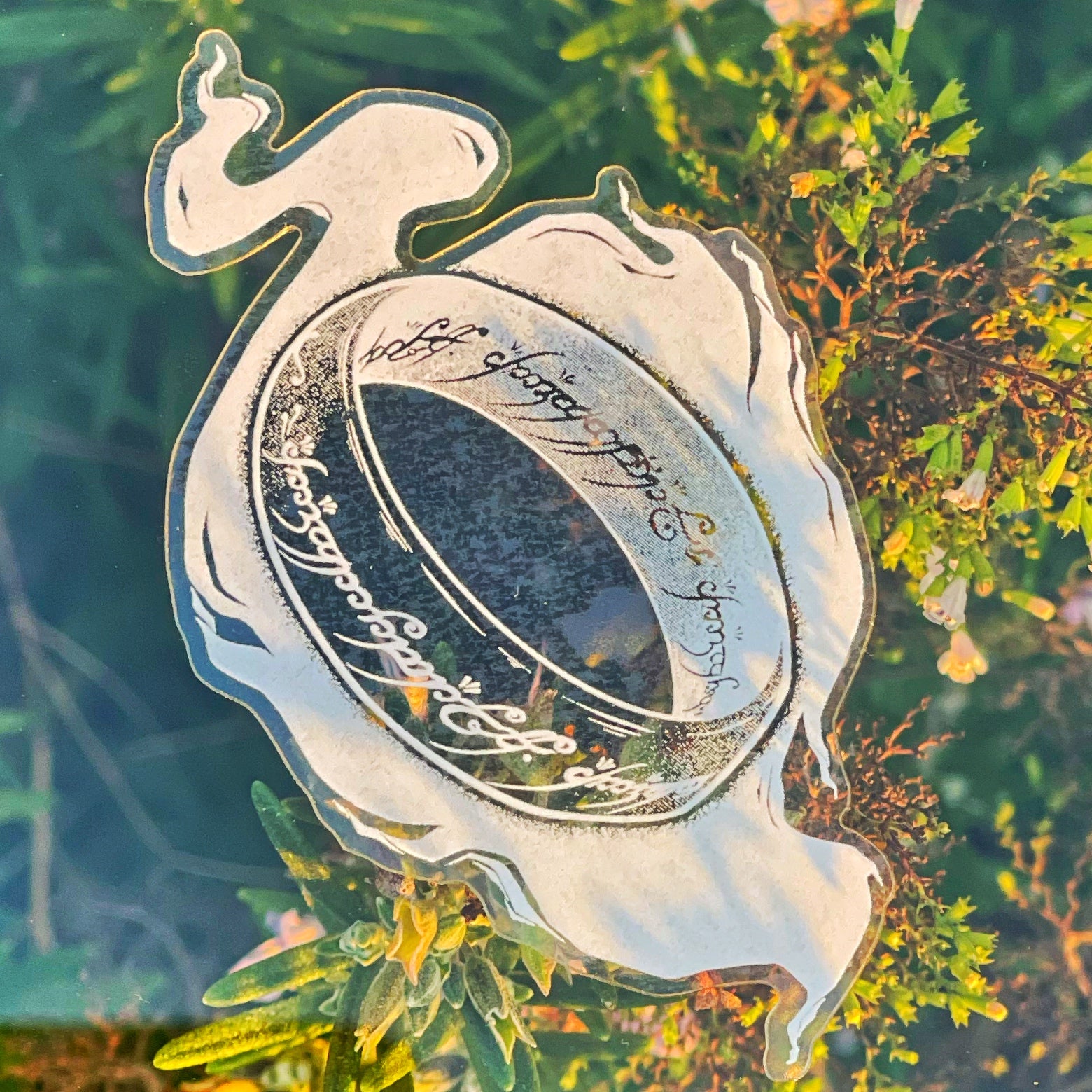 an image inspired by the one ring of lord of the rings rendered in white ink on clear vinyl
